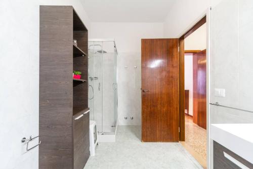 uma casa de banho com um chuveiro e uma porta de madeira em San Marco 4893 em Veneza
