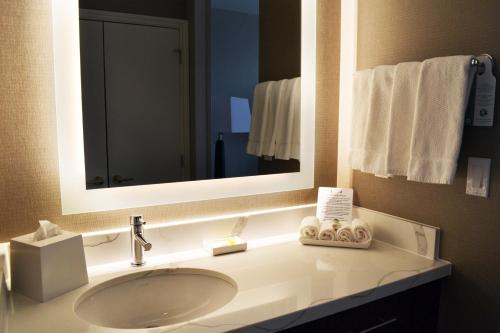 a bathroom with a sink and a mirror and towels at Staybridge Suites - Red Deer North by IHG in Red Deer