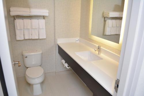 La salle de bains est pourvue de toilettes, d'un lavabo et d'un miroir. dans l'établissement Holiday Inn Express & Suites Waterville - North, an IHG Hotel, à Waterville
