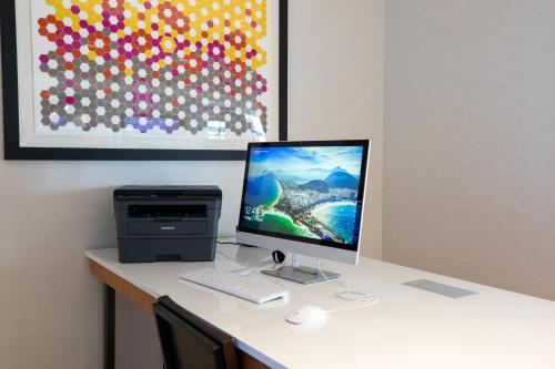 a desk with a computer monitor and a printer at Holiday Inn Express - Lethbridge Southeast by IHG in Lethbridge