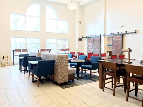 a dining room with tables and chairs and windows at Holiday Inn Express Hotel & Suites White River Junction, an IHG Hotel in White River Junction