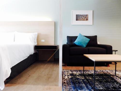 a bedroom and a living room with a bed and a couch at Staybridge Suites - Villahermosa Tabasco by IHG in Villahermosa