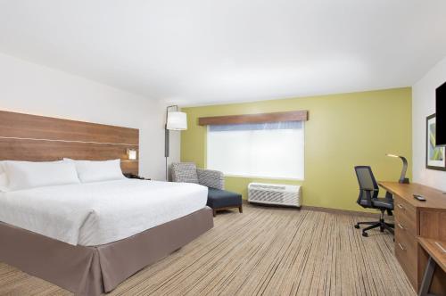a hotel room with a large bed and a desk at Holiday Inn Express Williamsburg by IHG in Williamsburg