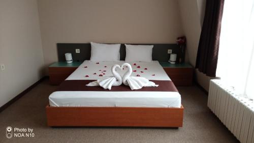 a bedroom with two white swans on a bed at Hotel Oppium Restaurant & Garden in Ruse