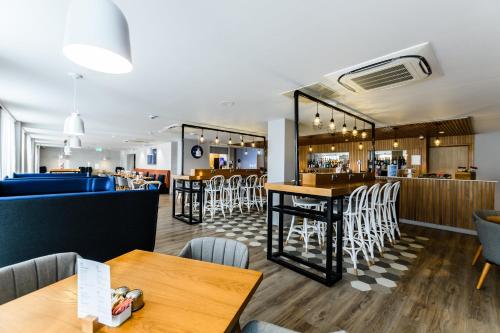 a restaurant with tables and chairs and a bar at Holiday Inn Express - Wigan by IHG in Wigan