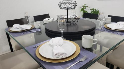 a dining table with a white plate with a napkin at DEPA 100 POR CIENTO FAMILIAR ACAPULCO CERCA DEL MAR CON ROFF GARDEN y JACUZZI in Acapulco