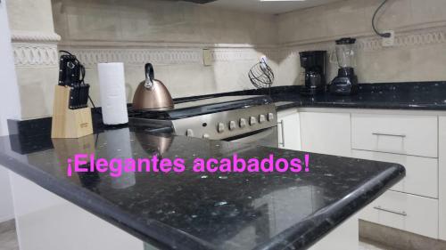 a kitchen with a stove and a counter top at DEPA 100 POR CIENTO FAMILIAR ACAPULCO CERCA DEL MAR CON ROFF GARDEN y JACUZZI in Acapulco