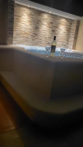 a bath tub with a bottle of wine and two glasses at DEPA 100 POR CIENTO FAMILIAR ACAPULCO CERCA DEL MAR CON ROFF GARDEN y JACUZZI in Acapulco