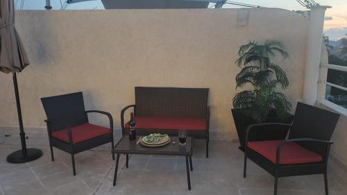 a patio with two chairs and a table with a plate on it at DEPA 100 POR CIENTO FAMILIAR ACAPULCO CERCA DEL MAR CON ROFF GARDEN y JACUZZI in Acapulco