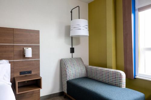 a chair in a hotel room with a lamp at Holiday Inn Express - Lethbridge Southeast by IHG in Lethbridge