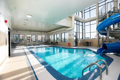 a large swimming pool with a slide in a building at Holiday Inn Express - Lethbridge Southeast by IHG in Lethbridge