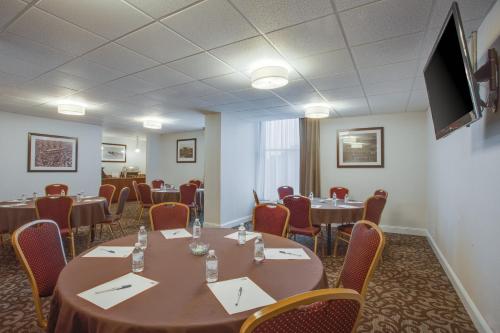 a conference room with tables and chairs and a flat screen tv at Holiday Inn Express Washington DC East- Andrews AFB by IHG in Camp Springs