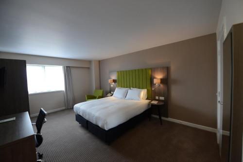 a hotel room with a large bed and a window at Holiday Inn Wolverhampton - Racecourse by IHG in Wolverhampton