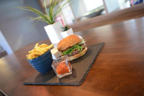 a sandwich and chips on a plate with a cup of fries at Holiday Inn Wolverhampton - Racecourse, an IHG Hotel in Wolverhampton