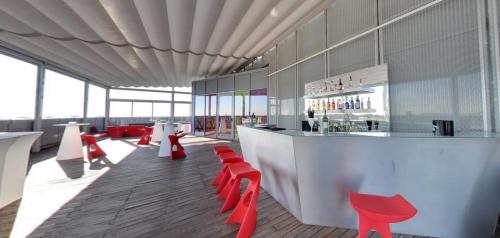 a bar with red chairs and a counter in a building at Crowne Plaza Verona Fiera by IHG in Verona