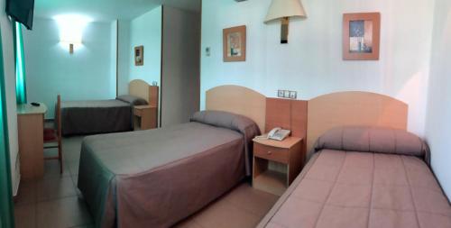 A bed or beds in a room at Hostal El Arco