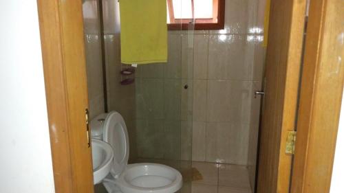 een badkamer met een wit toilet en een douche bij MARÉ - Paz e Sossego in Tramandaí