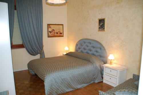 チヴィタノーヴァ・マルケにあるB&B Milùのベッドルーム1室(ベッド1台、青い椅子付)