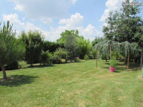 einen großen Garten mit Bäumen und einem Grasfeld in der Unterkunft Merveilleuses chambres d'hôtes à Panazol in Panazol