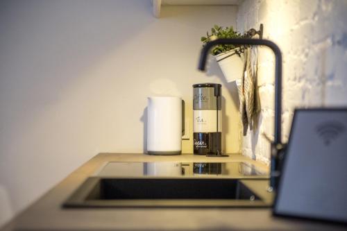 eine Küchentheke mit einer Spüle und einer Kaffeemaschine in der Unterkunft Downtown Apartment Rentals in Šiauliai