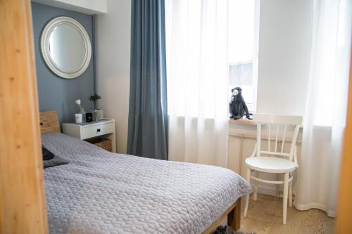 ein Schlafzimmer mit einem Bett, einem Stuhl und einem Fenster in der Unterkunft Downtown Apartment Rentals in Šiauliai