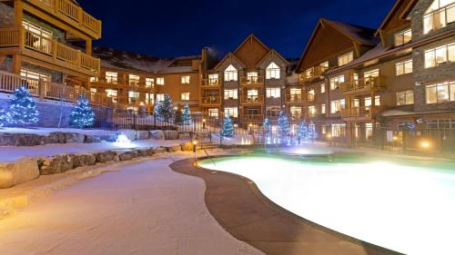 a resort with a pool in the snow at night at Stoneridge Mountain Resort in Canmore