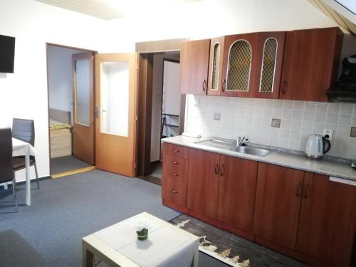 a kitchen with a sink and wooden cabinets at Apartmany Železná Ruda in Železná Ruda