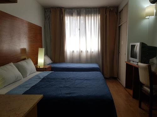 Habitación de hotel con 2 camas y TV en Al Porteño en Buenos Aires