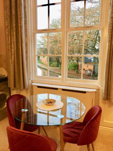 a glass table and chairs in front of a window at Velvet Nest 5 min walk from train station in Leamington Spa