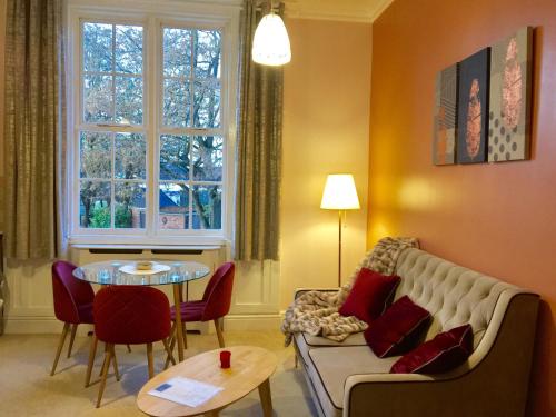 a living room with a couch and a table at Velvet Nest 5 min walk from train station in Leamington Spa