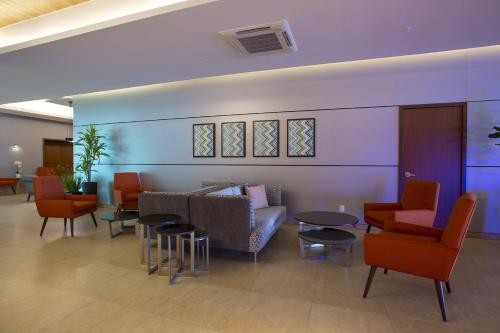 a waiting room with chairs and a couch and tables at Holiday Inn Express Mérida by IHG in Mérida