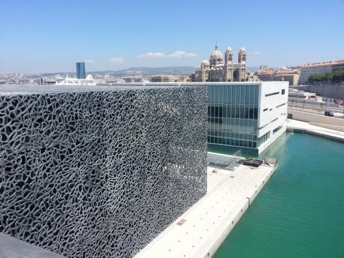 a building with a pool of water in front of it at Hôtel Marseille Centre Gare Saint-Charles in Marseille