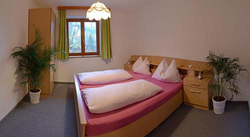 a bedroom with a bed and two potted plants at Apartmenthaus Kristall in Wagrain