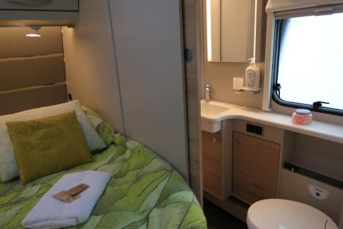 a small bathroom with a bed and a sink at Kamping u Łukasza in Zakopane