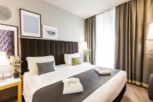 a hotel room with a large bed with two towels on it at Holiday Inn Milan Garibaldi Station by IHG in Milan