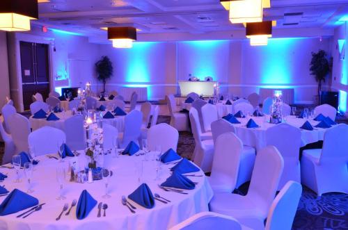 a conference room with white tables and chairs at Holiday Inn Orlando East-UCF Area by IHG in Orlando