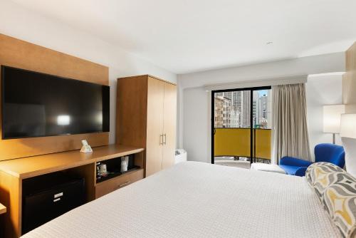 a hotel room with a bed and a flat screen tv at Best Western Red Coach Inn in San Francisco