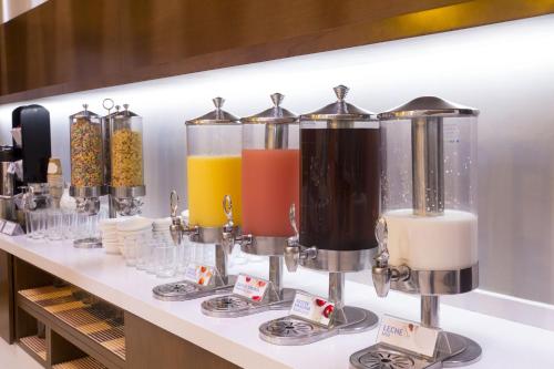 a shelf with a row of different colored juices at Holiday Inn Express Mérida by IHG in Mérida