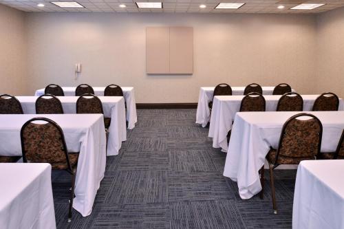 a conference room with tables and chairs and a screen at Holiday Inn Express Portland West/Hillsboro by IHG in Hillsboro