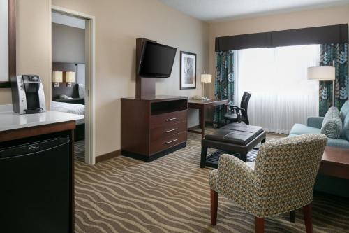 a hotel room with a bed and a living room at Holiday Inn Hotel & Suites Overland Park-West by IHG in Overland Park