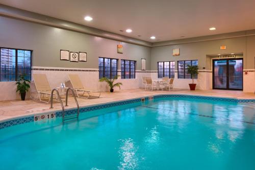 a swimming pool with blue water in a hotel at Staybridge Suites Peoria Downtown by IHG in Peoria