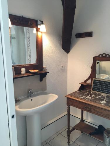une salle de bain avec un lavabo et un miroir dans l'établissement Domaine de Fondain, à Laqueuille