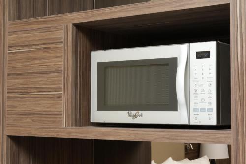 a microwave oven sitting on a wooden shelf at Holiday Inn Express & Suites Monterrey Valle by IHG in Monterrey