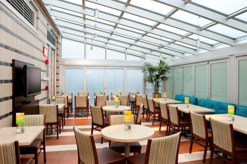 une salle à manger avec des tables, des chaises et une télévision dans l'établissement Holiday Inn Express - Times Square South, an IHG Hotel, à New York