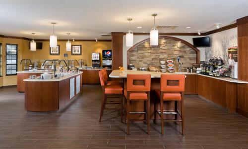 a restaurant with a bar with orange bar stools at Staybridge Suites Montgomeryville, an IHG Hotel in North Wales