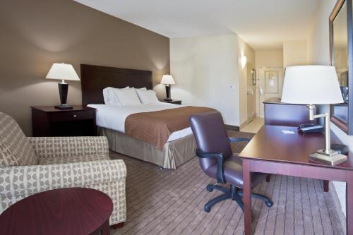 a hotel room with a bed and a desk and chair at Holiday Inn Express- North Palm Beach and IHG Hotel in Juno Beach
