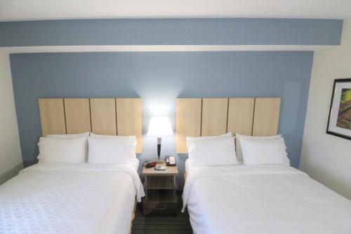 two beds in a hotel room with blue walls at Candlewood Suites - Memphis East by IHG in Memphis