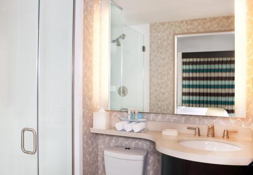a bathroom with a sink and a mirror and a toilet at Holiday Inn Express - Times Square South, an IHG Hotel in New York