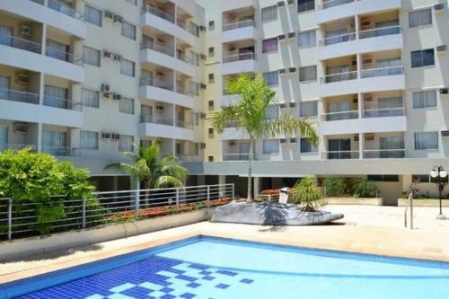 einem Pool vor einem großen Apartmenthaus in der Unterkunft Serra Park Apart in Rio Quente