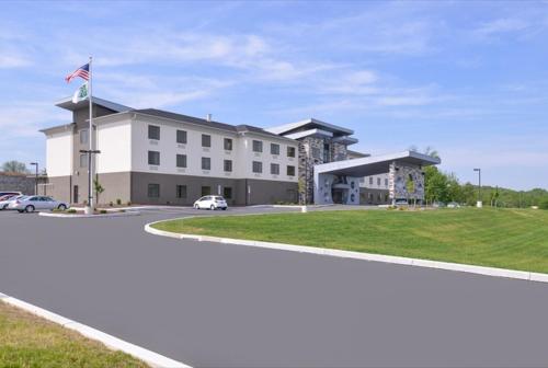 a large white building with a flag on it at Holiday Inn Express & Suites Shippensburg by IHG in Shippensburg
